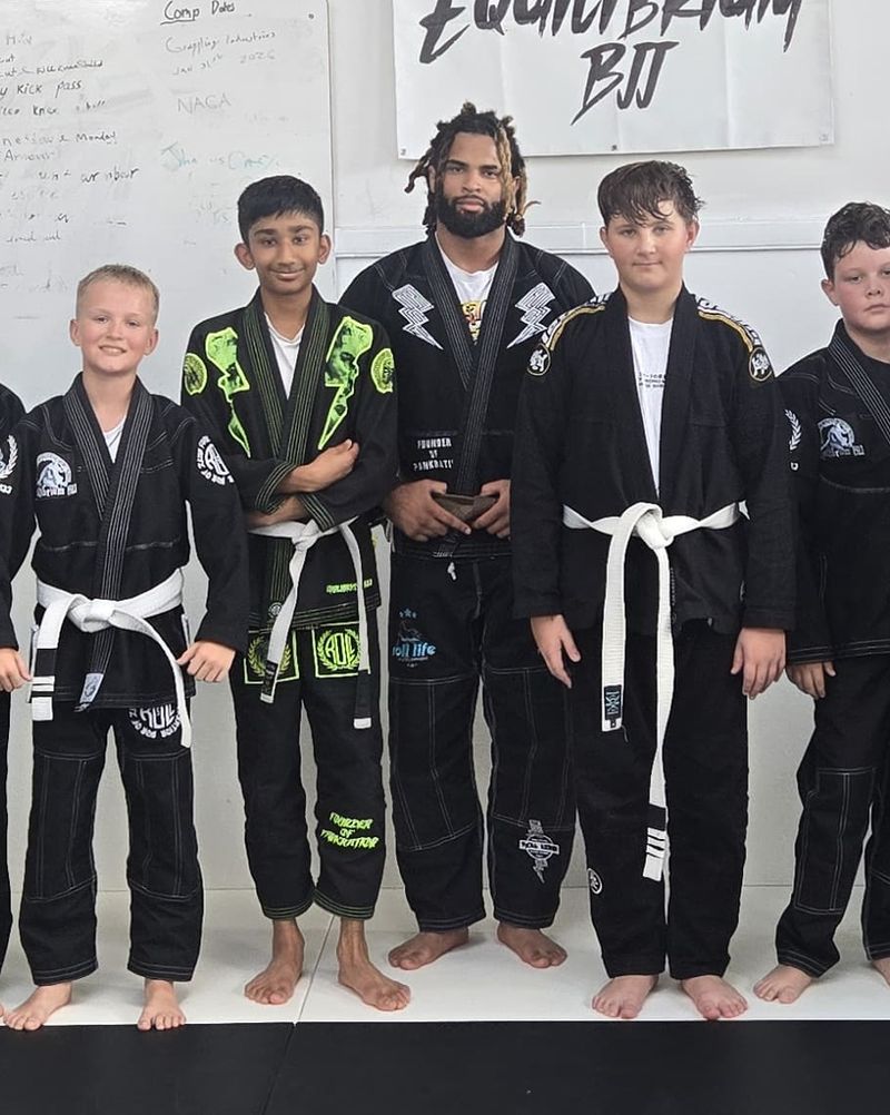 Equilibrium kids team lined up on the mat with their coach