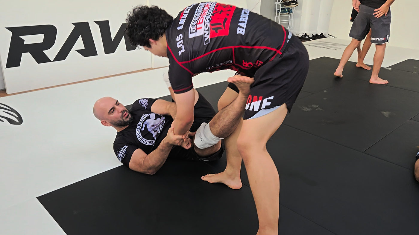 Coach teaching a No-Gi leg entry